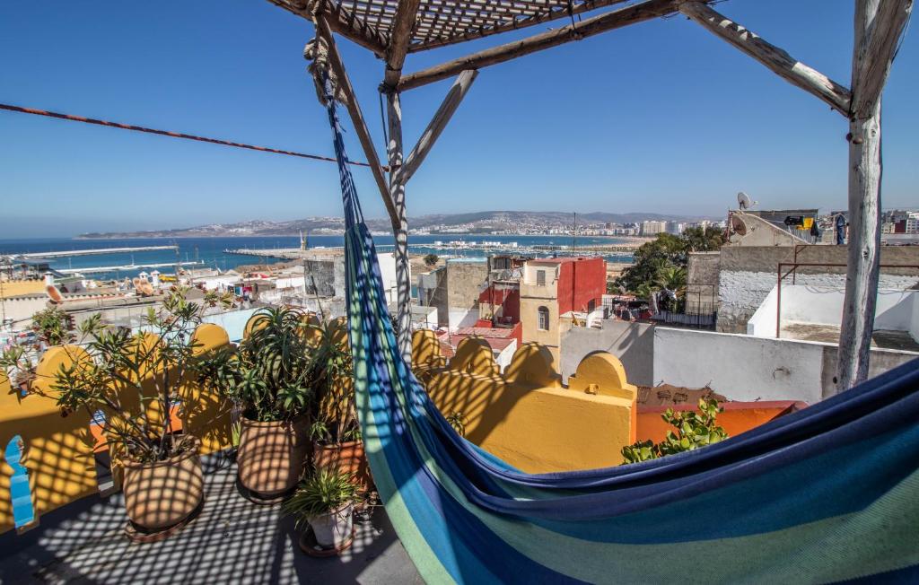 a hammock on a balcony with potted plants at Bayt Alice Hostel in Tangier