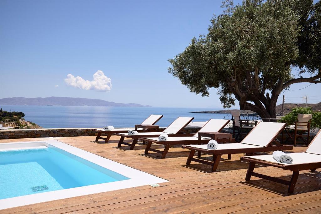 a row of lounge chairs next to a swimming pool at Kanala Studios in Kithnos