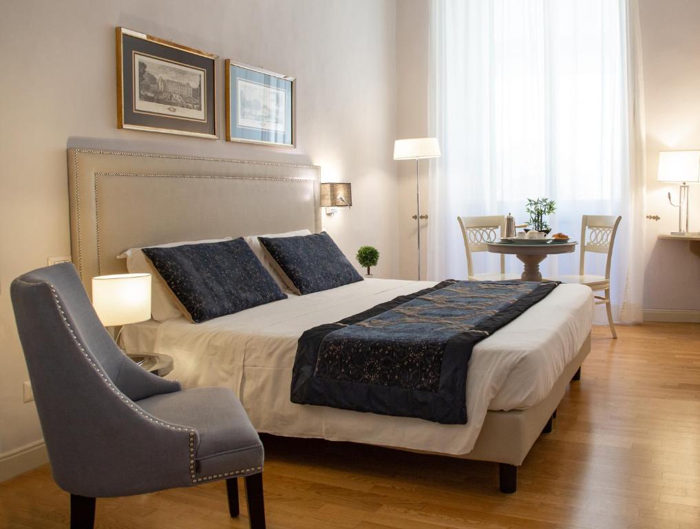 a bedroom with a large bed and a chair at Boutique Hotel del Corso in Florence
