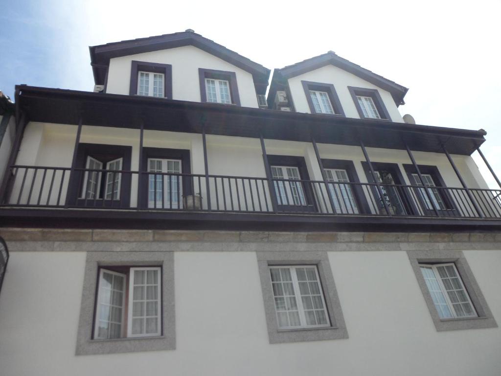 a white building with a balcony on top of it at Florinda in Chaves
