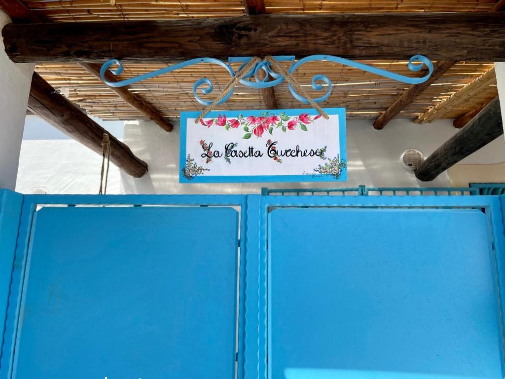 un cartello appeso sopra due porte blu di La casetta turchese a Pula