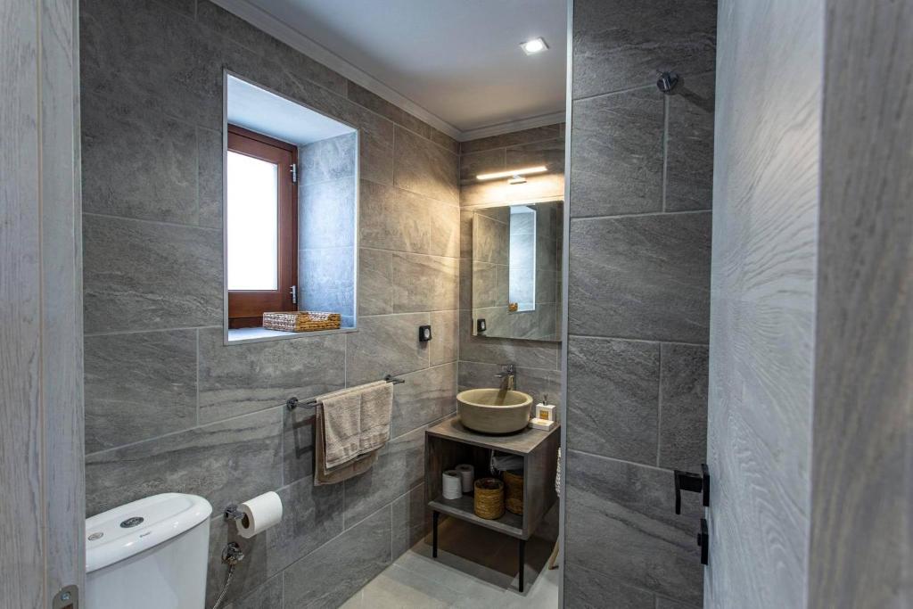 y baño con lavabo, aseo y espejo. en Althea Apartments 2, en Halki
