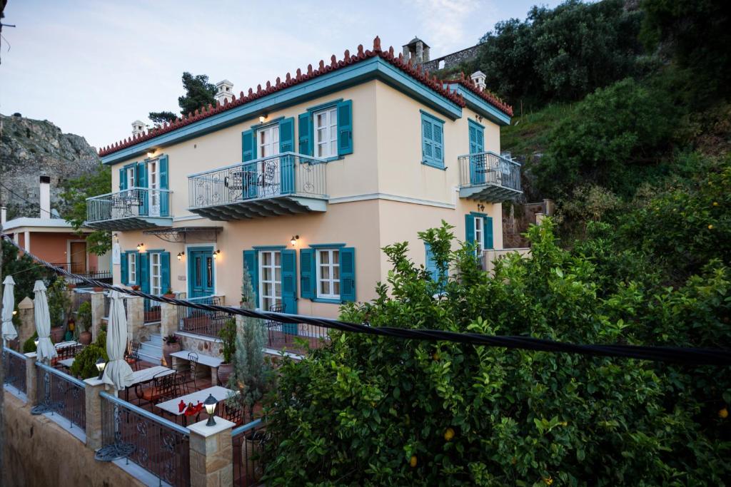 Casa grande con ventanas azules y balcón. en Acronafplia Pension A, en Nauplia