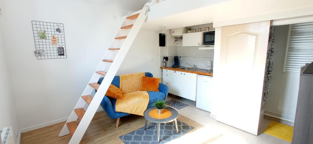 ein kleines Wohnzimmer mit einem blauen Sofa und einer Leiter in der Unterkunft Appart Coeur de Rouen - Majestic in Rouen