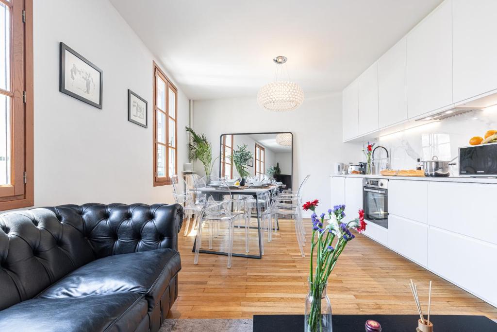 Il comprend un salon avec un canapé en cuir noir et une cuisine. dans l'établissement FEEL HOME - ALPHONSE KARR, à Nice