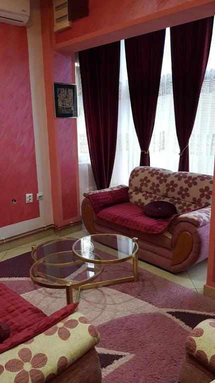 - un salon avec un canapé et une table en verre dans l'établissement Apartman Lazić No-2, à Gračanica