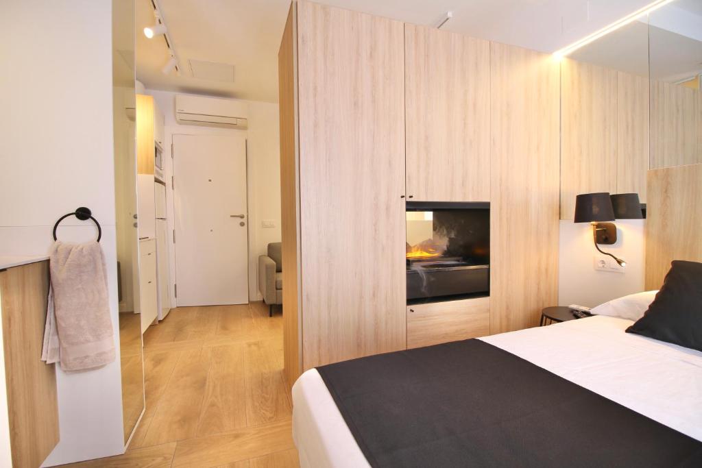1 dormitorio con 1 cama y chimenea en ESTUDIO PORT EXPERIENCE, en Tarragona