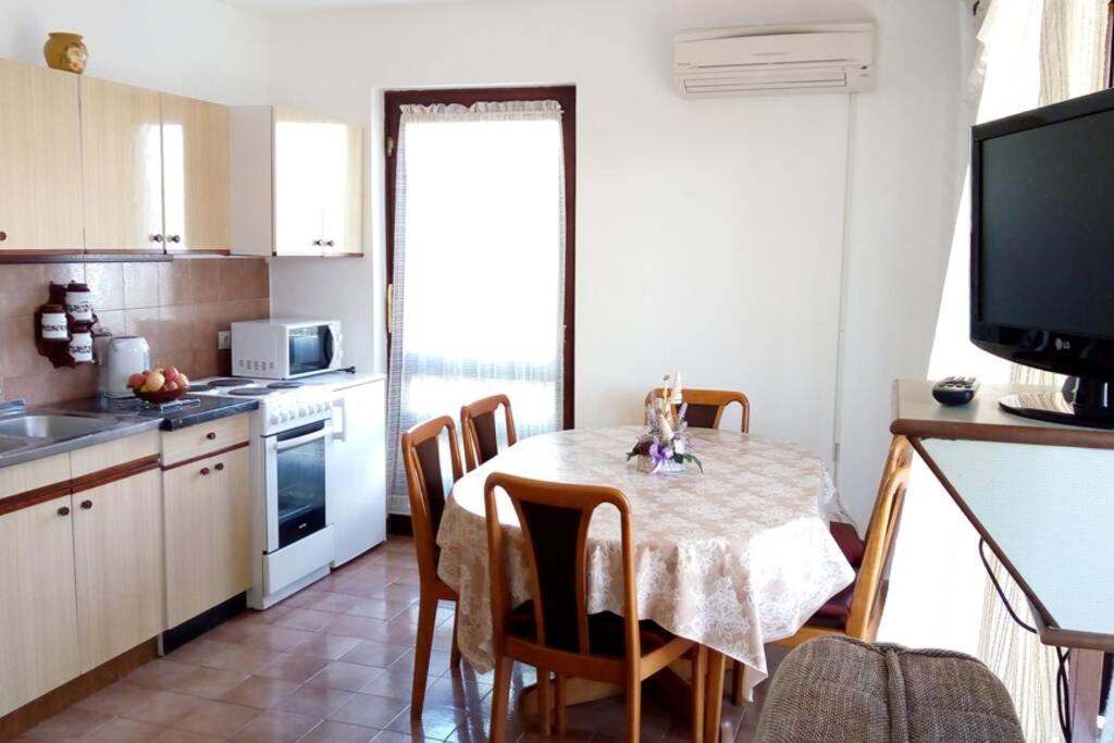 a kitchen with a table and chairs in a room at Apartment Zdenka in Raša