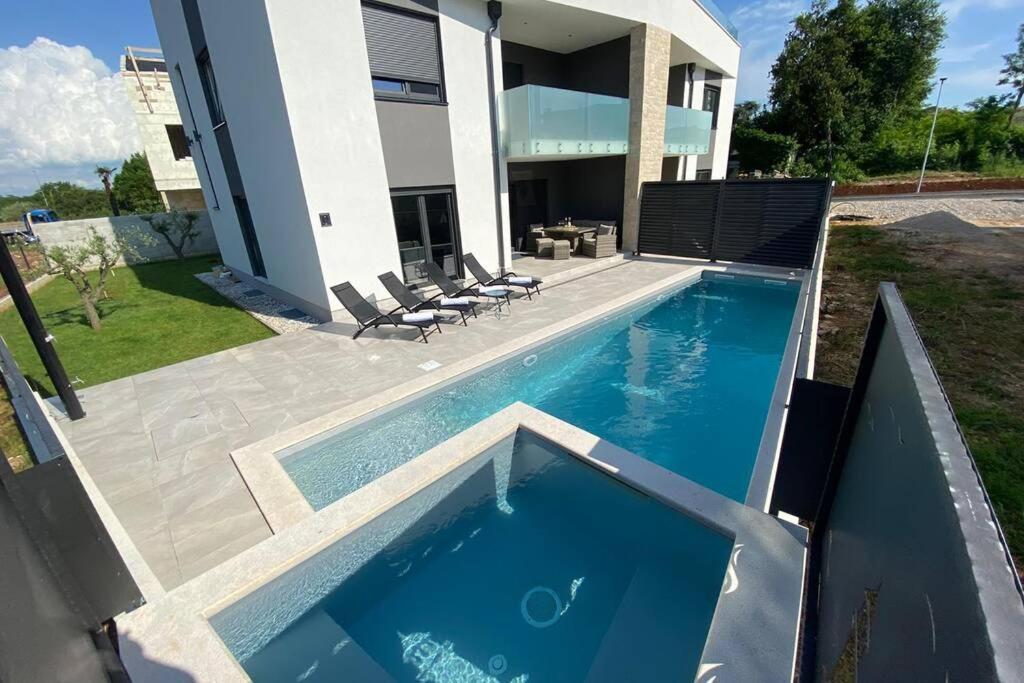 una piscina frente a una casa en Villa Lighthouse mit Pool und Jacuzzi, en Bašanija