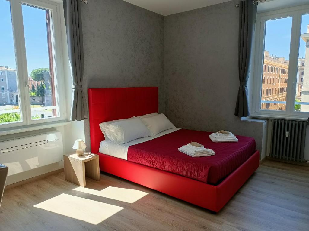 a red bed in a room with two windows at SunnyCornerinRHome in Rome