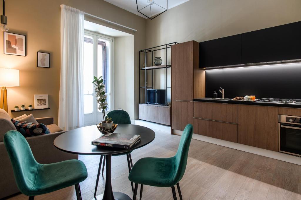 sala de estar con mesa y sillas verdes en Palazzo Nanà Suites & Apartments, en Nápoles