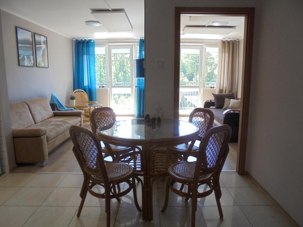 a living room with a dining room table and chairs at Apartament dwupokojowy 150 m do morza in Jarosławiec