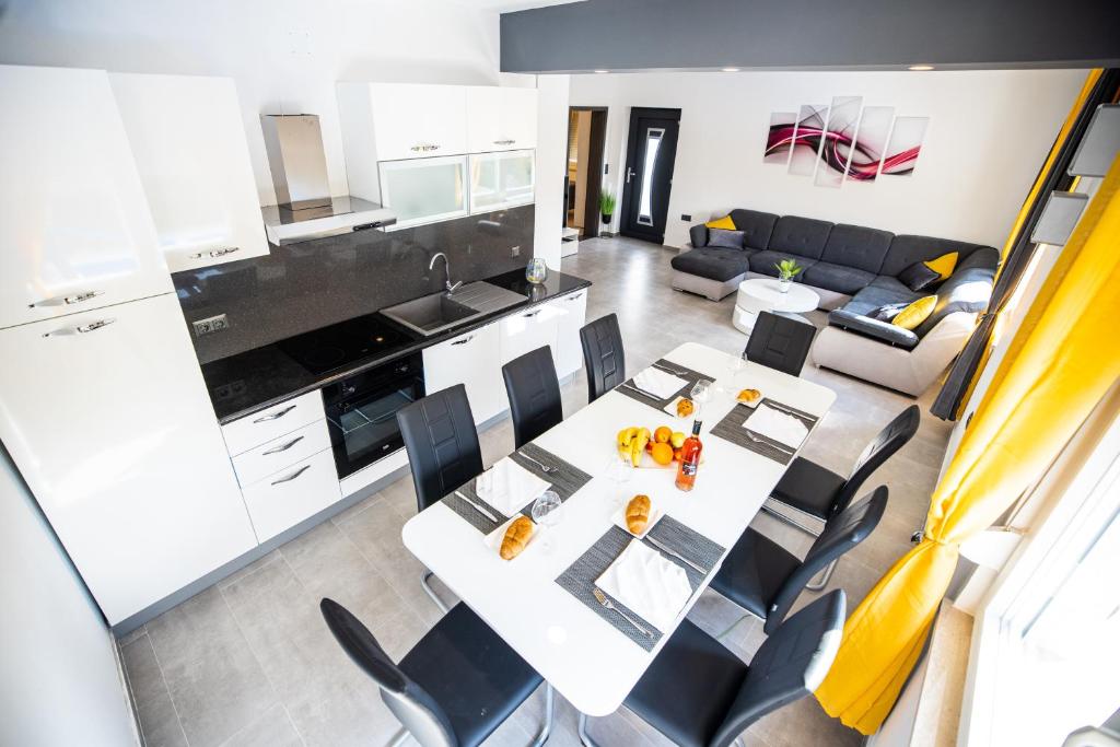 a kitchen and living room with a table and chairs at Villa Nila Zadar in Zadar