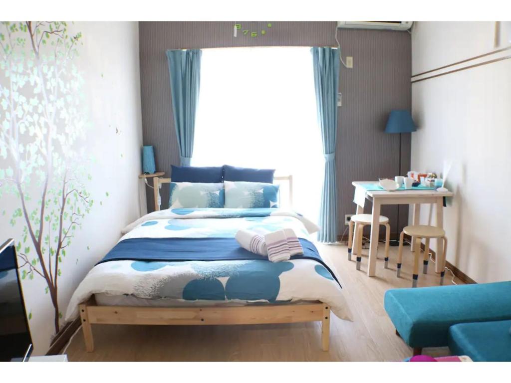 een slaapkamer met een bed, een tafel en een raam bij Maison Cresta Urayasu - Vacation STAY 11150 in Urayasu