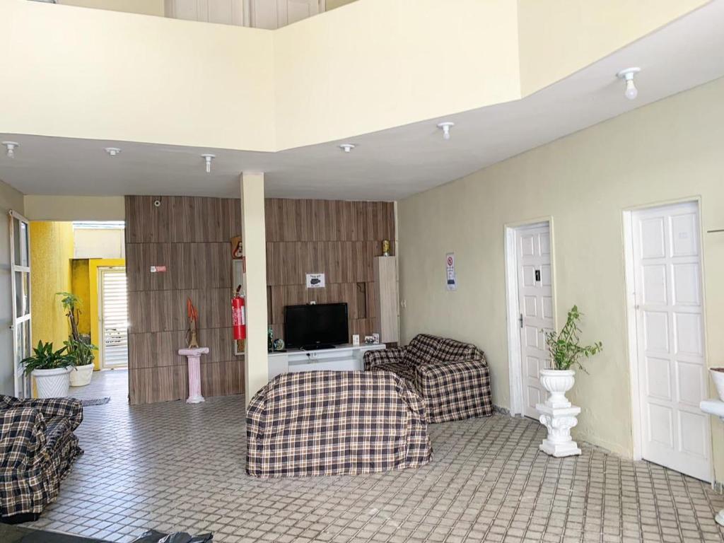 ein Wohnzimmer mit 2 Sofas und einem TV in der Unterkunft Hostel da Paz in Maceió