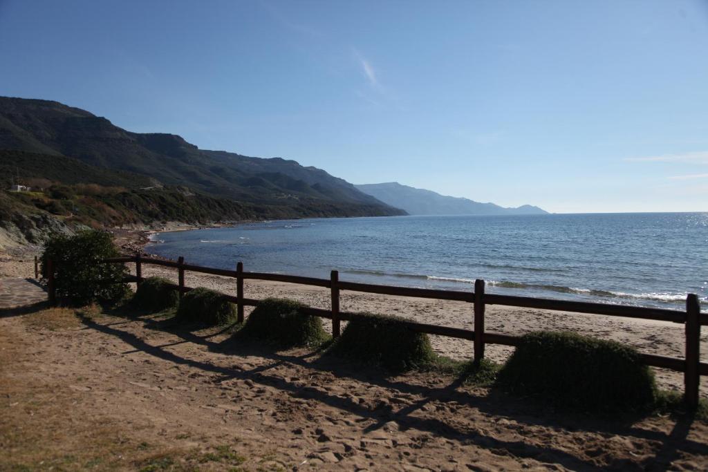 een hek op een strand naast het water bij AFFITTA CAMERE CASA DELLE ROSE in Villanova Monteleone