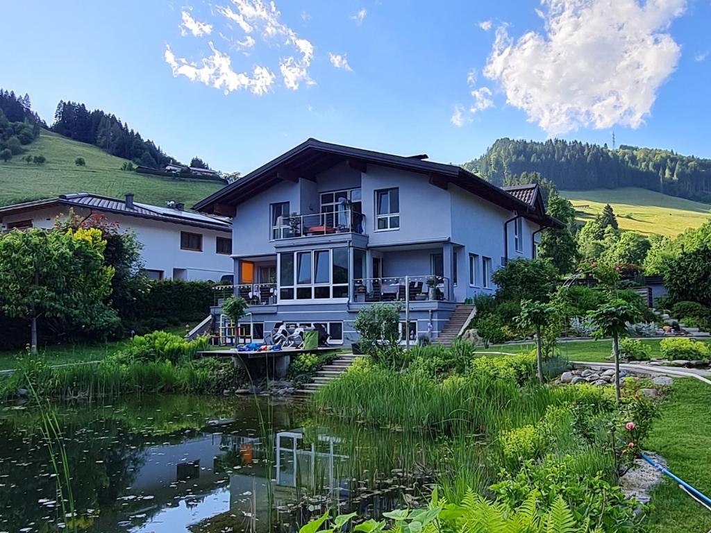 a house with a pond in front of it at Apartment Familie Grünauer in Sankt Johann im Pongau