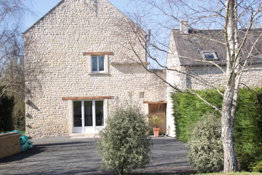 a brick house with a driveway in front of it at Maison en pleine nature proche plage Omaha Beach! in Mandeville-en-Bessin