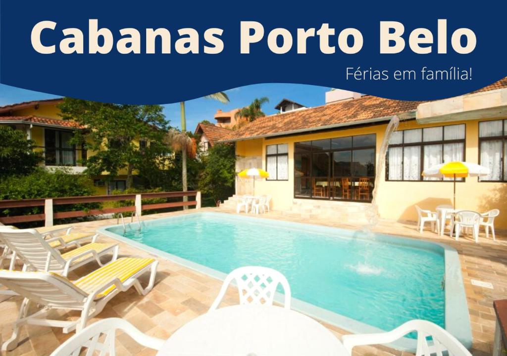 a swimming pool with chairs and a house at Pousada Cabanas Porto Belo in Bombinhas