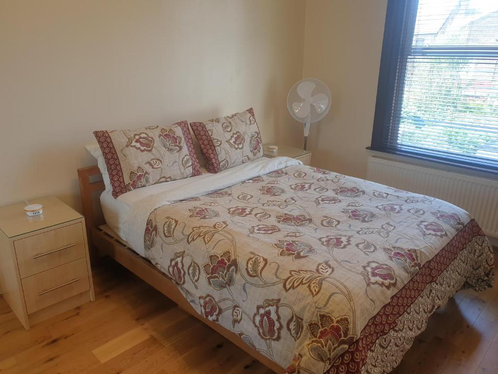 Schlafzimmer mit einem Bett, einem Ventilator und einem Fenster in der Unterkunft London Luxury Apartments 5 min walk from Ilford Station, with FREE PARKING FREE WIFI in Ilford