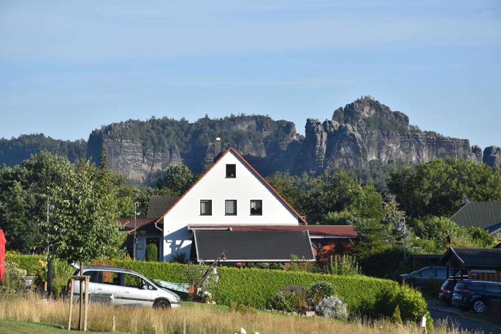 a white house with a mountain in the background at Ferienwohnung Am Hegebusch in Altendorf