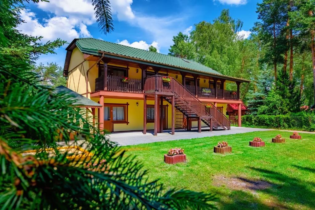 a house with a balcony and a yard at Willa Magda in Okuninka