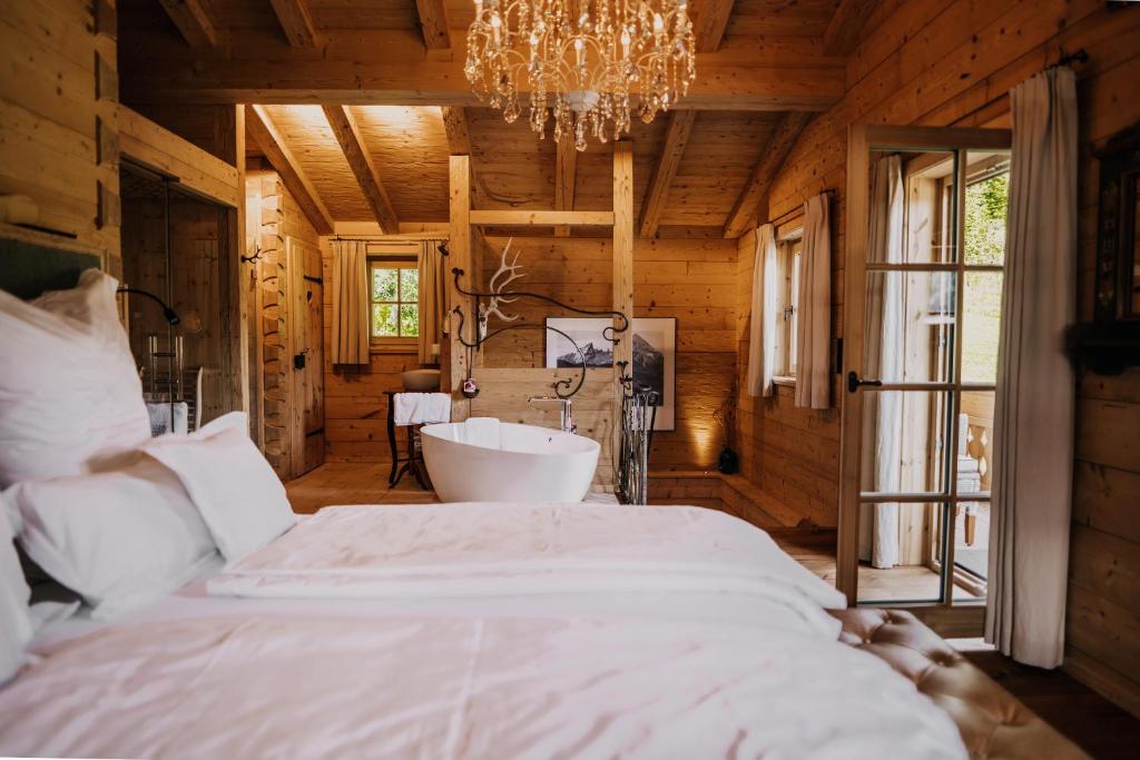 ein Schlafzimmer mit einem großen weißen Bett und einem Kronleuchter in der Unterkunft Chalet Watzmann in Schönau am Königssee