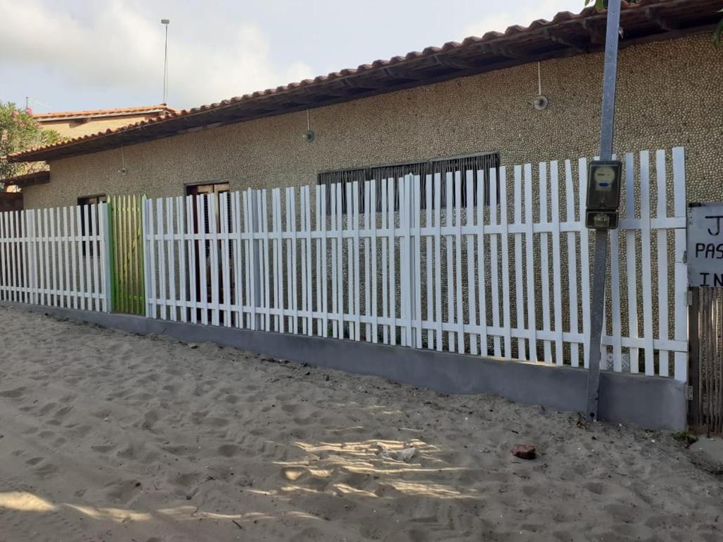 a white picket fence in front of a building at casa sarnambi in Atins