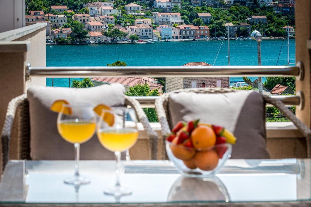 einen Tisch mit zwei Gläsern Wein und eine Schale Obst in der Unterkunft Apartments Du Lux in Mokošica