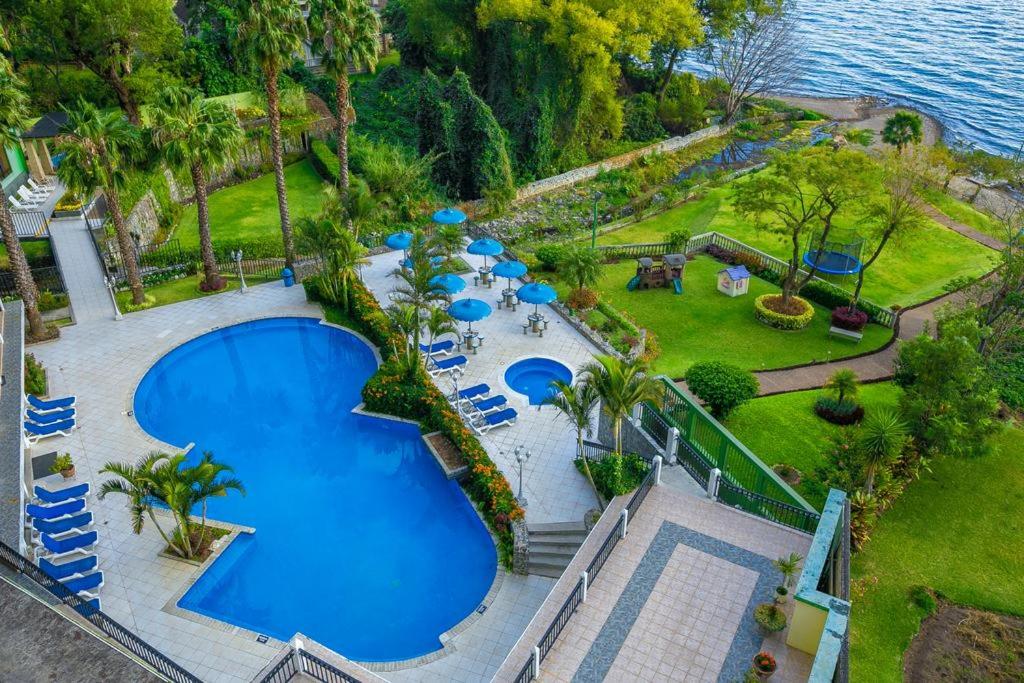 an aerial view of a swimming pool with chairs and the water at Apartamento Riviera, lake Panajachel in San Jorge La Laguna