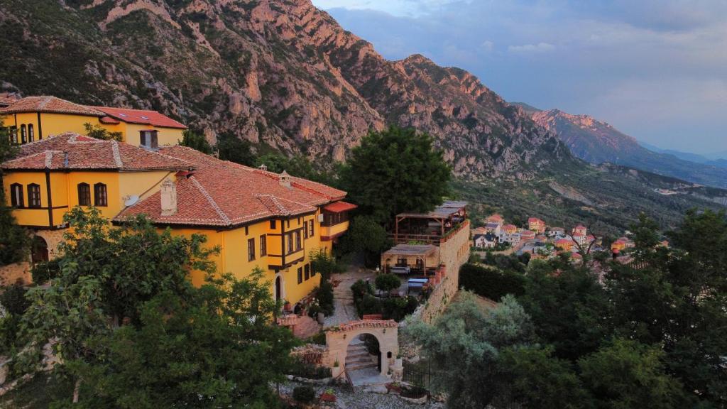 a group of houses on a hill with a mountain at Rooms Merlika -Inside the Castle- in Krujë