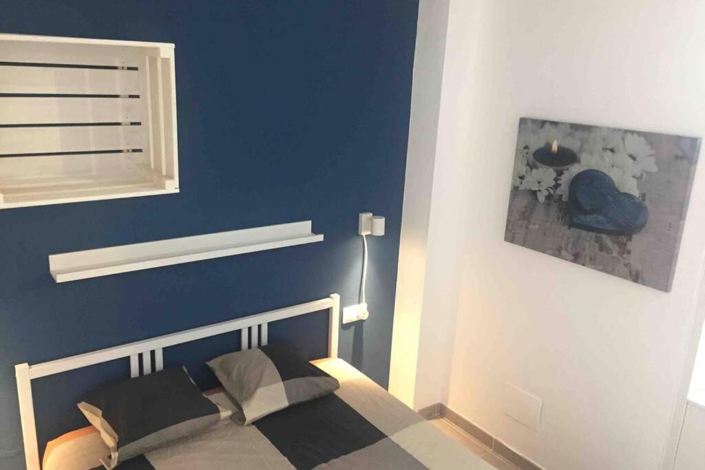 Un dormitorio con una pared azul y una cama en Sea View Loft, en Playa Blanca