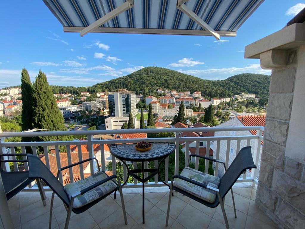 uma varanda com uma mesa e cadeiras e uma vista em Apartment Sandra FREE PRIVATE PARKING em Dubrovnik