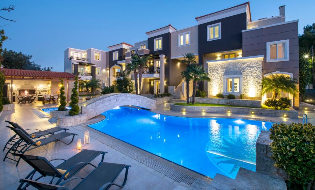 uma villa com piscina à noite em Artdeco Luxury Suites em Korakiaí