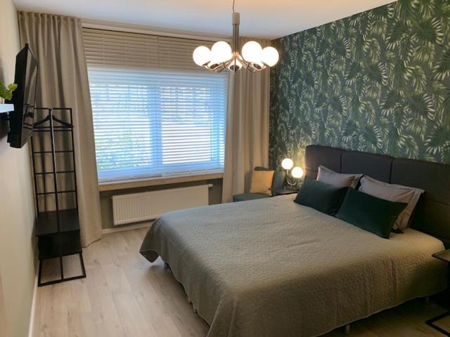 een slaapkamer met een groot bed en een raam bij BnB De Koepoort in Mechelen