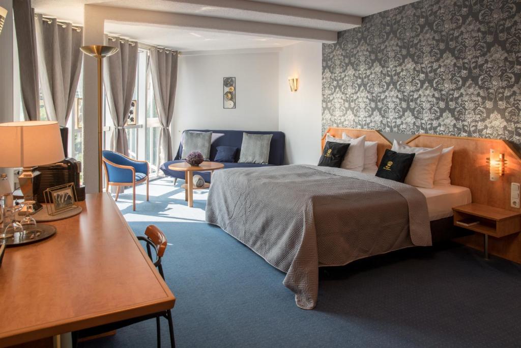 ein Hotelzimmer mit einem Bett, einem Tisch und Stühlen in der Unterkunft Saar Galerie in Saarburg