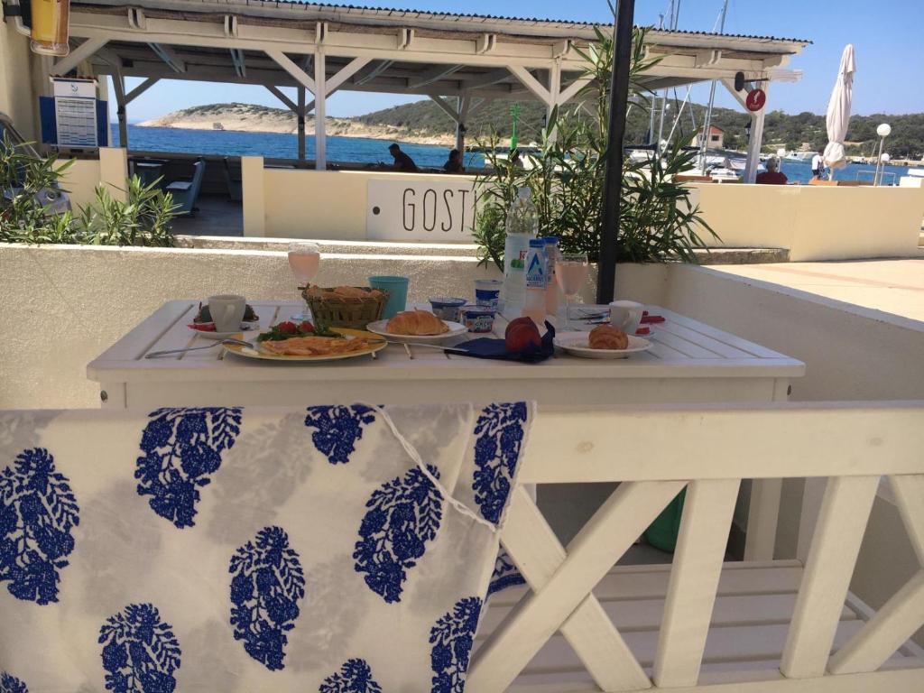 un tavolo con piatti di cibo in cima a un balcone di VILLA IL BLU direkt am Meer a Martinšćica