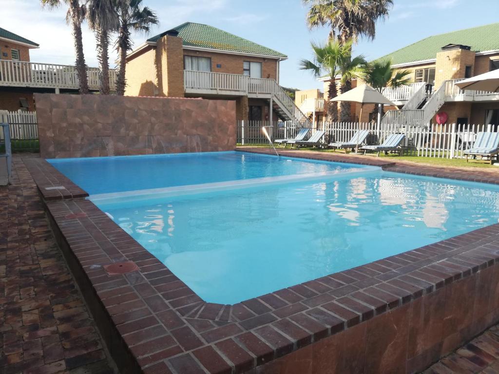 a swimming pool at a resort with blue water at Shearwater 106 in Sedgefield