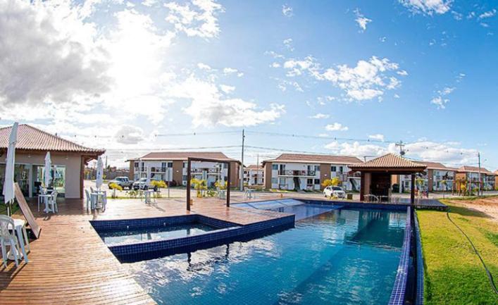 a swimming pool in front of a house at Apartamento Beira Rio no Condomínio Brisas do Lago in Paulo Afonso