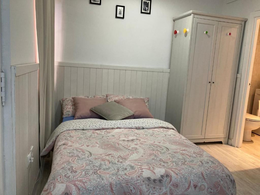 a small bedroom with a bed with a pink blanket at 2-Estudio Zona Chamberí Quevedo in Madrid