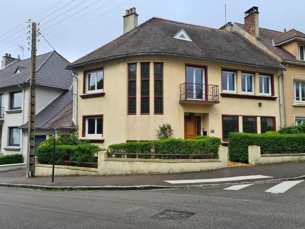 a large yellow house with a black roof at Au Soleil Boulonnais in Boulogne-sur-Mer