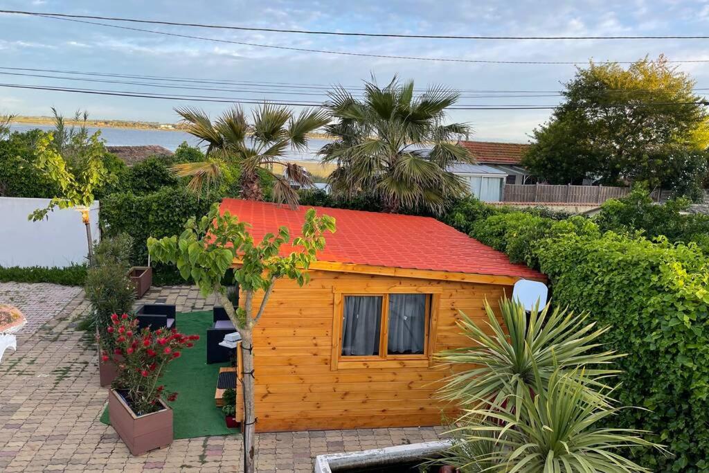una piccola casa in legno con tetto rosso di Chalet belle vue, jacuzzi, piscine, terrasse, climatisé a Marseillan