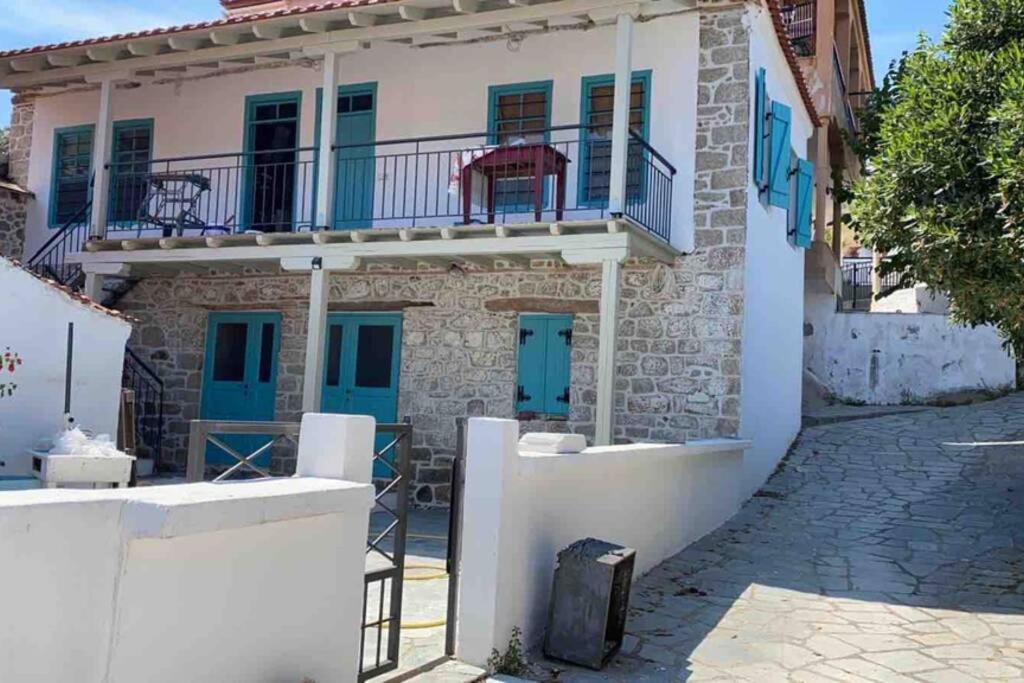 uma casa com portas azuis e uma varanda em Sfeervol gerenoveerd huis in oud Grieks dorp em Sikia