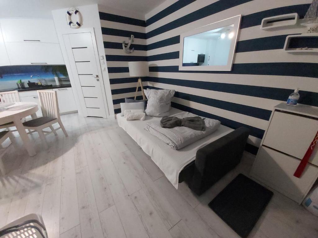 a bedroom with blue and white striped walls and a bed at Apartament na Wzgórzu in Mechelinki