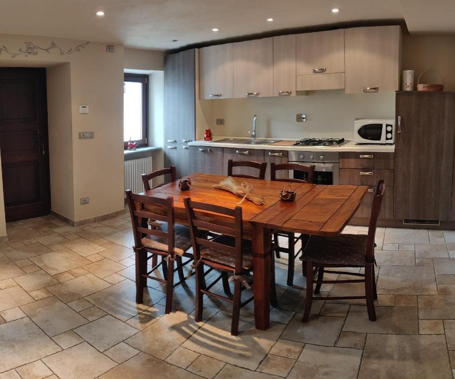 a kitchen with a wooden table and some chairs at CASA VACANZE CLO 3 CAMERE 2 BAGNI in Aosta