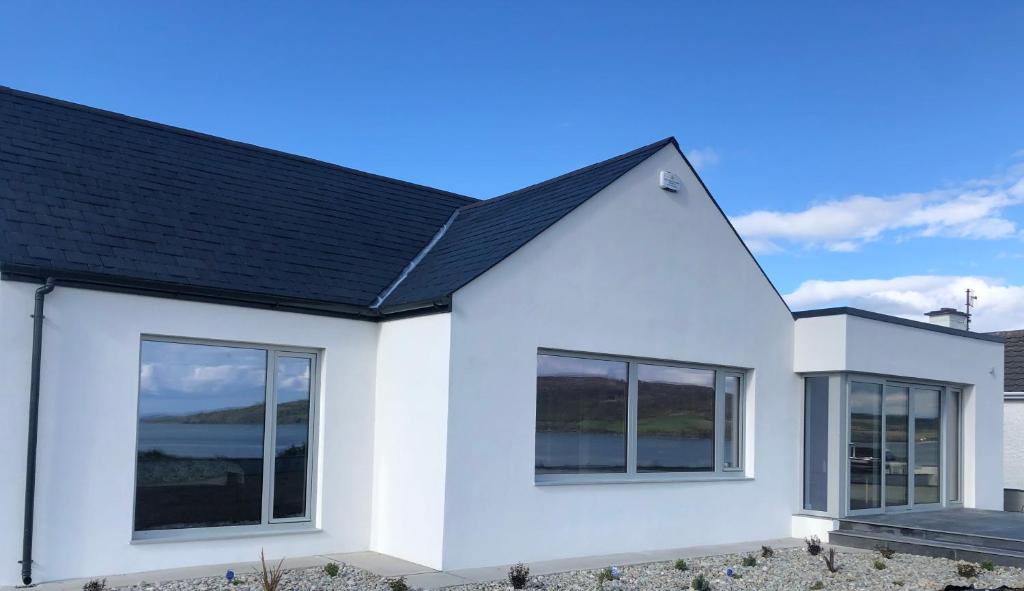a white house with a black roof at Sea Vista - Rathmullan in Rathmullan
