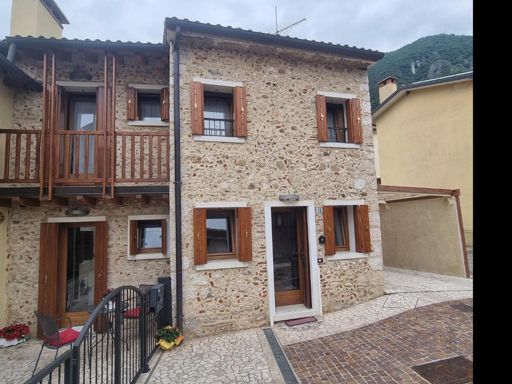 een stenen huis met een veranda en een balkon bij Giulietta e Romeo in Pove del Grappa