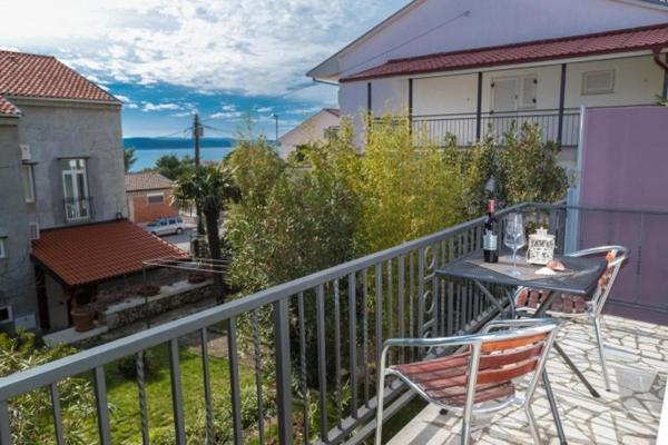 a patio with a table and chairs on a balcony at Apartments Kari in Crikvenica