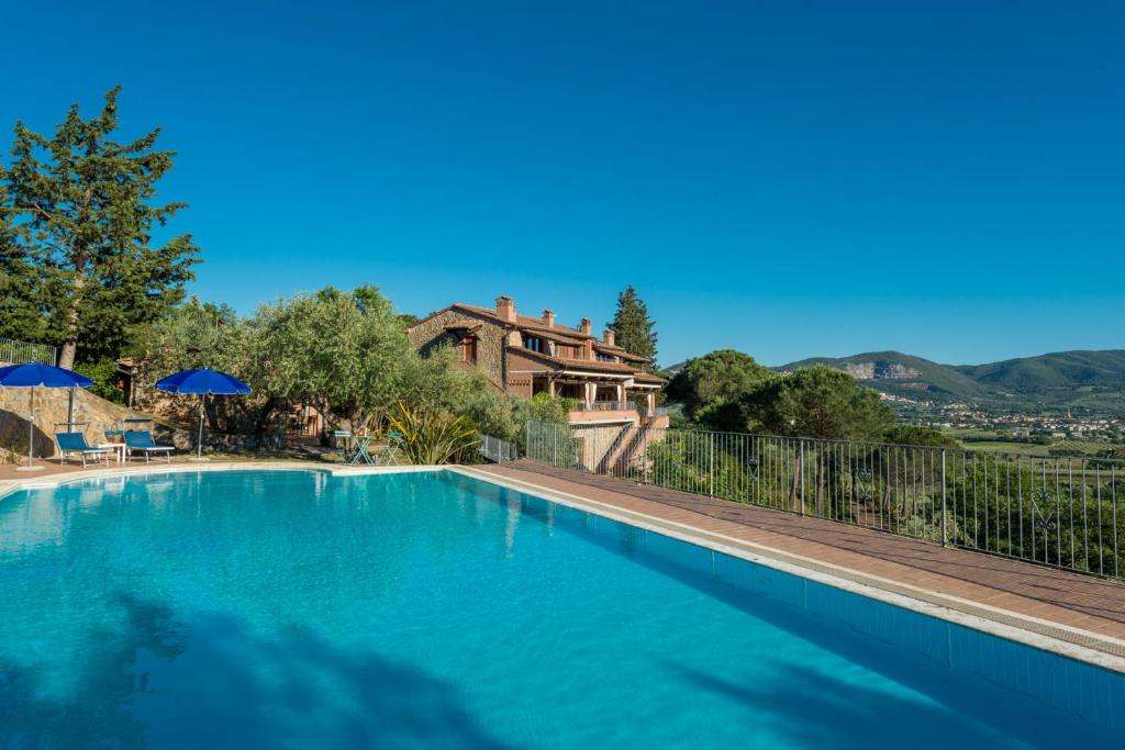 a swimming pool in front of a house at Podere La Tona in Gavorrano
