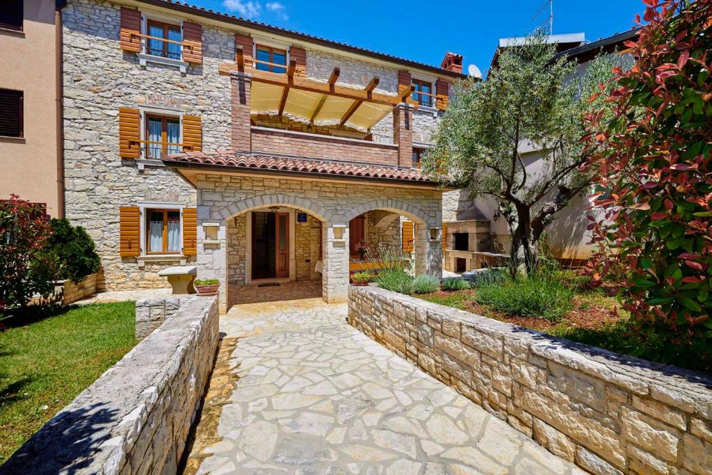 a large stone house with a stone wall at Holiday home in Medulin/Istrien 9006 in Medulin